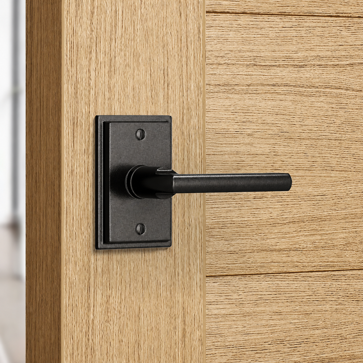 A black single dummy lever on a stepped rectangular rosette with exposed screws, mounted on a white oak door with no keyhole or turn button.